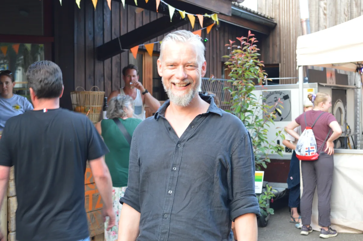 Ein Mann steht vor einer Aperol Spritz Bar.